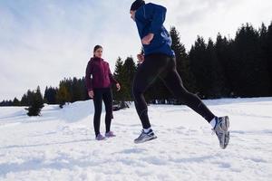 pareja trotando afuera en la nieve foto