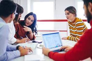 grupo de estudiantes trabajando juntos en un proyecto escolar en una tableta en una universidad moderna foto