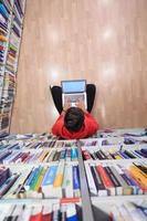 the students uses a notebook, laptop and a school library photo