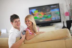 pareja joven relajada viendo la televisión en casa foto