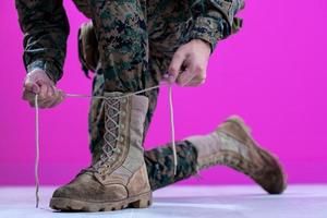 soldado atando los cordones de sus botas foto