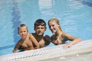 happy young family have fun on swimming pool photo