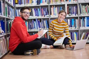 los estudiantes usan un cuaderno, una computadora portátil y una biblioteca escolar foto