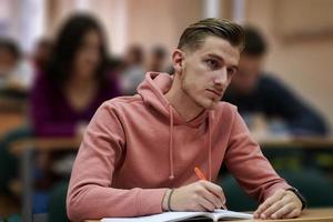 estudiante tomando notas mientras estudia en la escuela secundaria foto