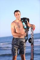 Portrait of a young  kitsurf  man at beach on sunset photo