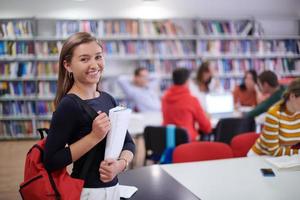 el estudiante usa un cuaderno y una biblioteca escolar foto