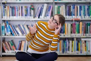 the student uses a notebook and a school library photo