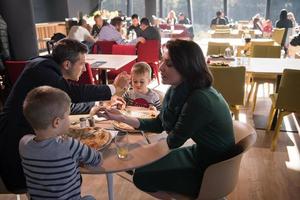 Young parents enjoying lunch time with their children photo