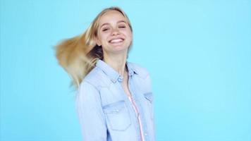 jeune femme blonde devant des sourires et des vagues de fond bleu clair video