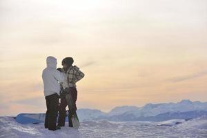 pareja de snowboarders en la cima de la montaña foto