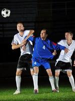 football players in action for the ball photo