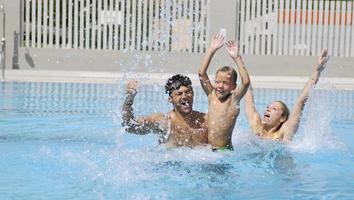 happy young family have fun on swimming pool photo