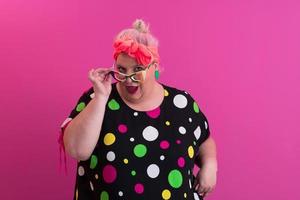 Happy Plus Size Woman Wearing Eyeglasses Smiling To Camera Standing Over Pink Background. Cheerful Millennial Female In Eyewear Posing In Studio. photo