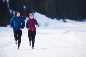 pareja trotando afuera en la nieve foto