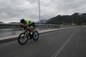 atleta de triatlón montando en bicicleta en el entrenamiento matutino foto