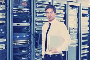 businessman with laptop in network server room photo