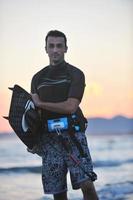 Portrait of a young  kitsurf  man at beach on sunset photo