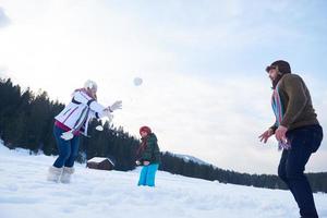 familia feliz jugando juntos en la nieve en invierno foto