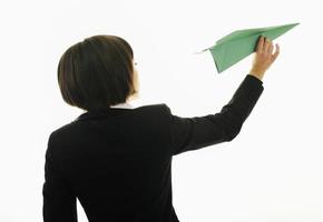mujer de negocios lanzando un avión de papel foto