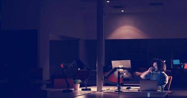 hombre trabajando en una computadora en una oficina oscura foto