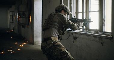 soldier in action near window changing magazine and take cover photo