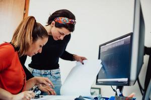 dentro de la industria pesada, un ingeniero industrial de fábrica mide con un calibrador y en una computadora personal diseña un modelo 3d foto