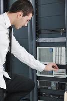 young engeneer in datacenter server room photo