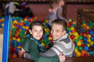 parents and kids playing in the pool with colorful balls photo