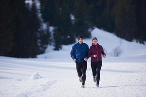 pareja trotando afuera en la nieve foto