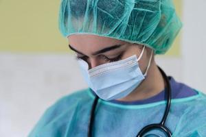 retrato de un médico triste y abrumado con mascarilla protectora, con aspecto exhausto, deprimido y preocupado debido al brote de coronavirus. estrés emocional, trabajadores de la salud y covid-19. foto