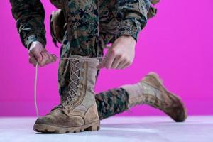 soldado atando los cordones de sus botas foto