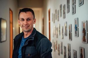 a portrait of a man in a work suit standing in the hallway of a factory photo