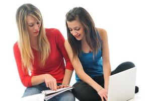 dos chicas jóvenes trabajan en una laptop aislada foto