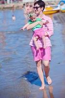 mamá y bebé en la playa se divierten foto