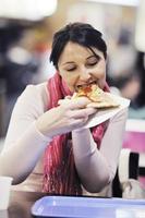 mujer come pizza en el restaurante foto