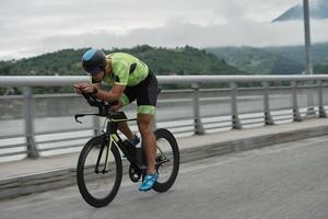 atleta de triatlón montando en bicicleta en el entrenamiento matutino foto