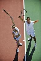 feliz pareja joven jugar al tenis al aire libre foto