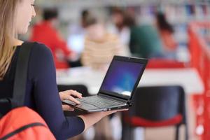 el estudiante usa un cuaderno y una biblioteca escolar foto