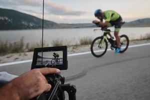 cinematographer taking action shot of triathlon bike athlete photo