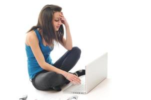 una joven trabaja en una laptop aislada en blanco foto
