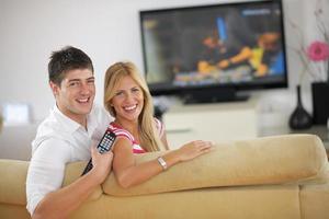 pareja joven relajada viendo la televisión en casa foto