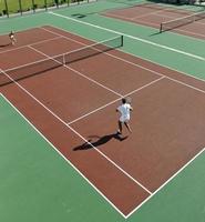 feliz pareja joven jugar al tenis al aire libre foto