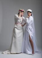 Portrait of two beautiful young bride in wedding dresses photo