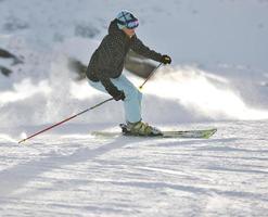 mujer esquiando en la nieve fresca en la temporada de invierno foto