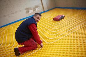 workers installing underfloor heating system photo