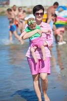 mamá y bebé en la playa se divierten foto