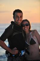 surf couple posing at beach on sunset photo