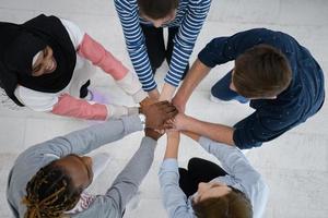 vista superior de un grupo diverso de personas de pie abrazando y simbolizando la unión foto