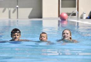 happy young family have fun on swimming pool photo