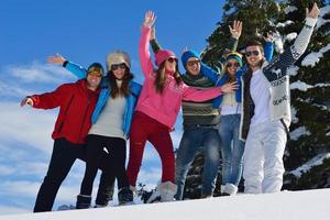 los amigos se divierten en invierno con nieve fresca foto